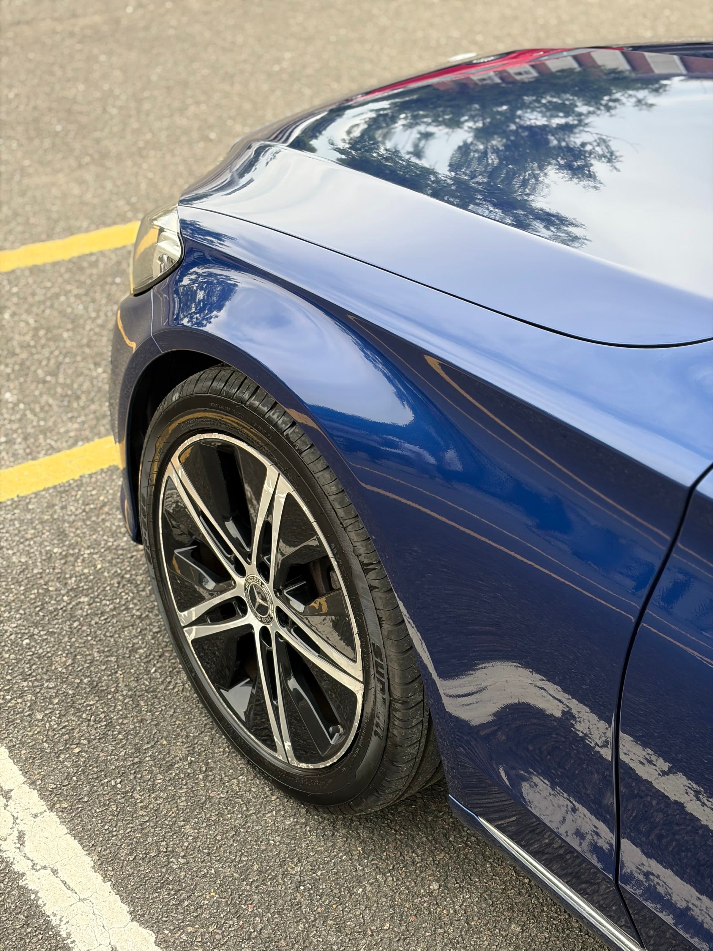 Gloss reflections across the bonnet and front quarter of a blue Mercedes C200 after machine polishing